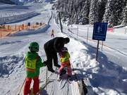 I bambini vengono aiutati nella salita allo skilift a piattello.