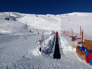 Tappeto della scuola di sci alla stazione a monte della cabinovia