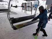 Il sedile viene spazzato dalla neve con una scopa all’ingresso.