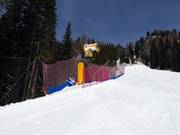 Potente cannone da neve sulla pista di rientro a valle verso Pozza di Fassa