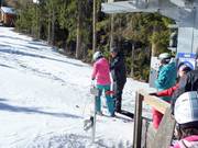 Il personale aiuta a salire sulla sciovia a piattello